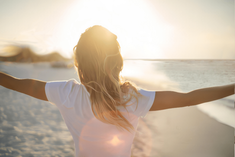 Woman on the beach with her arms open